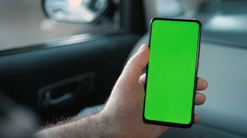 Handheld Camera: Back View of Man in car Holding Chroma Key Green Screen Video stock 165398038