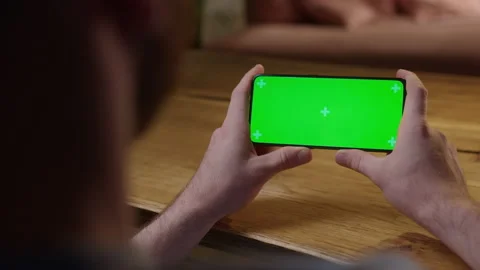 Handheld Camera: Back View of Young Man at Home Sitting on a Wood Desk using Stock Footage 165291407