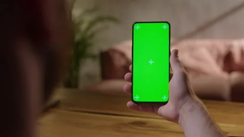Handheld Camera: Back View of Young Man at Home Sitting on a Wood Desk using Stock Footage 165293420