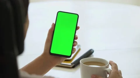 Handheld Camera: business woman using smartphone viewing green screen on mobile Stock Footage 143625032