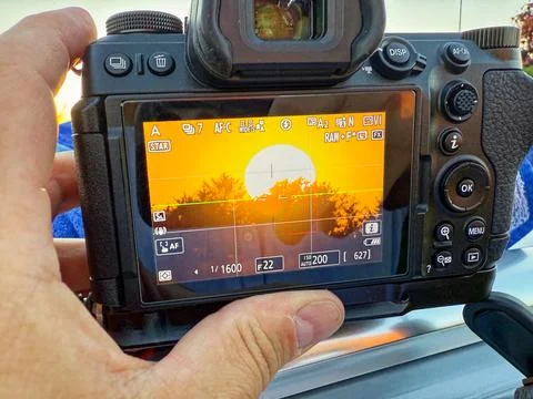 Handheld camera framing a sunset dropping to the horizon Stock Photos