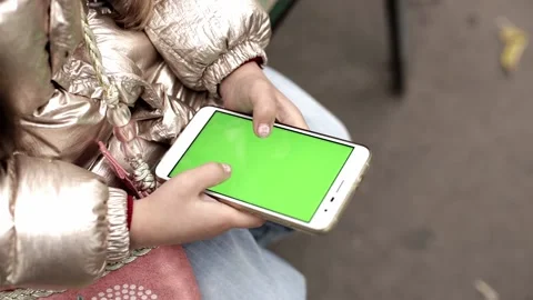 Handheld camera. Point of view of little girl at street Using Phone with green Stock Footage 162047627
