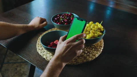 Handheld camera point of view of man at phone withe green screen for copy space. 動画素材 197372627