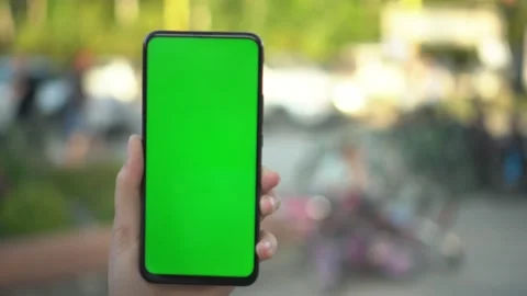Handheld Camera: Point of View of woan at street Using Phone With Green Mock-up Stock Footage 137985111