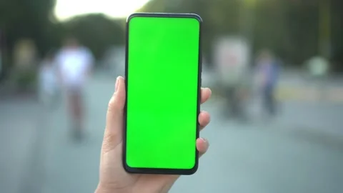 Handheld Camera: Point of View of woan at street Using Phone With Green Mock-up Stock Footage 138008110