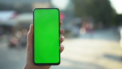 Handheld Camera: Point of View of woan at street Using Phone With Green Mock-up Stock Footage 138132747