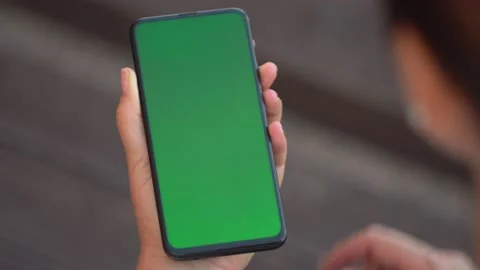 Handheld Camera: Point of View of Woman at street Using Phone With Green Mock-up Stock Footage 136741735