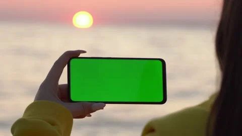 Handheld Camera: Point of View of Woman at beach Using Phone With Green Mock-up Stock Footage 142003697
