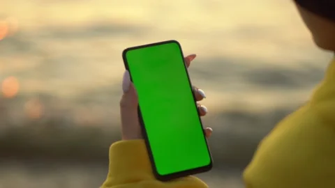Handheld Camera: Point of View of Woman at beach Using Phone With Green Mock-up Stock-Footage 143608383