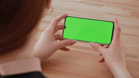 Handheld Camera: Point of View of woman Using Phone With Green Mock-up Screen Ch Stock Footage 148751322
