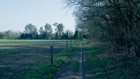 Handheld camera walking along a rural countryside path Stock Footage 335027191