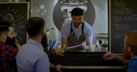 HANDHELD Cheerful waiter taking order inside a food truck Vidéo 115666089