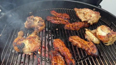 Handheld Close Up of Chicken Pieces and Pork Ribs Grilling on Charcoal BBQ Stock-Footage 336985223