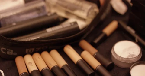Handheld close up of different types of makeup and equipment displayed on table Stock Footage 156005785