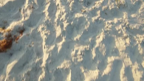Handheld Close Up of Footprints in Sunlit Beach Sand Texture Stock Footage 340464852