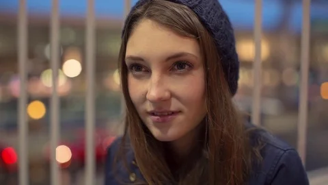 Handheld close-up of happy woman looking away while sitting on bridge at airport Stock Footage