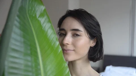 Handheld Close-up portrait of smiling young woman by leaf Stock Footage 115060260