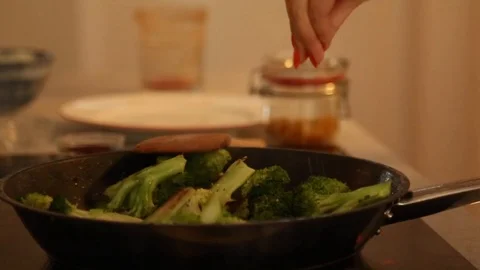 Handheld close-up shot adding spices and raisings in the frying pan Stock Footage 114846861