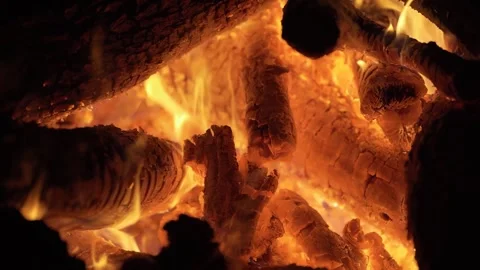Handheld close-up shot of glowing orange flames flickering between burning Stock Footage 339678083