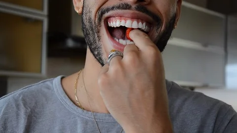 Handheld close-up shot of a man drinking and eating 스톡 동영상 115059995