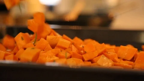 Handheld close-up shot a man laying diced carrots in a baking pan 스톡 동영상 114846815