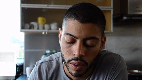 Handheld close-up shot of a man sipping wine in the kitchen Video stock 115059998