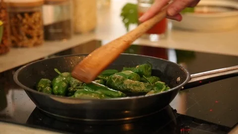 Handheld close-up shot of a man stirring pepper in frying pan on the stove Video stock 114846762