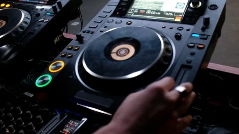 Handheld close-up shot of a man working on the DJ console Stock Footage 114886102