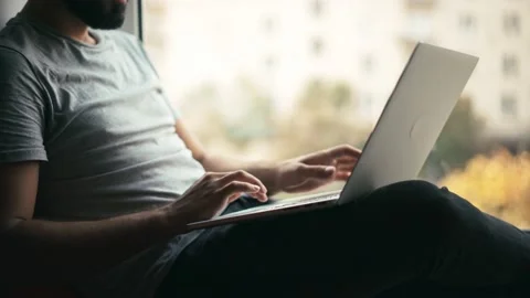 Handheld close-up shot of a man's hands while he is working on his laptop. Stock Footage 141640439