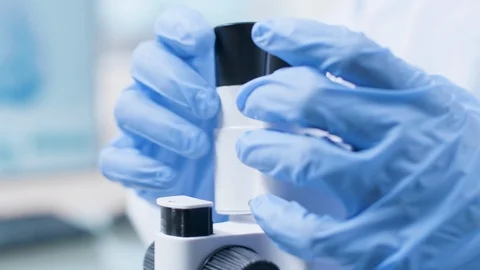 Handheld close up shot of professional scientist in coverall looking into the Stock Footage 108738762