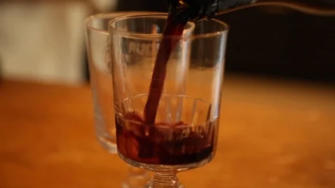 Handheld close-up shot of wine being poured in a glass on the table Video stock 114846863