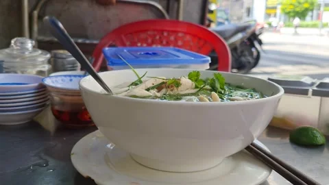 Handheld Close-up of Steaming Vietnamese Chicken Pho Ga on Stainless Steel Table Vídeos de archivo 331646581