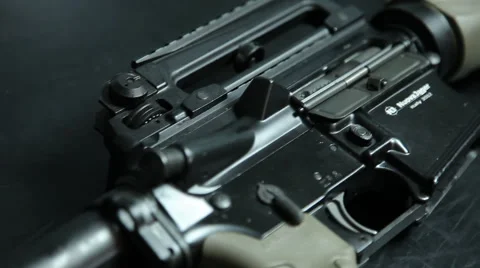 Handheld closeup moving across the body of a assault rifle diagonally. Stock Footage 64092402