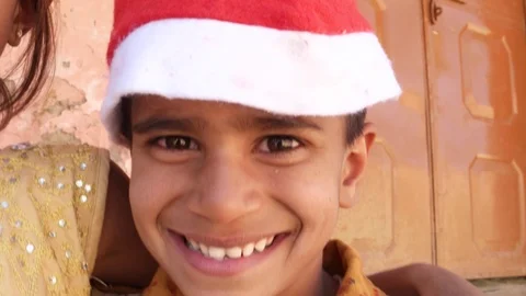 Handheld closeup pan across three smiling kids wearing Santa hats  Stock Footage 69888646