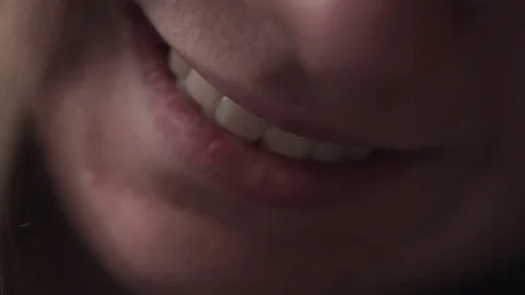 Handheld closeup shot of teen girl mouth in sunset light near window smiling Stock Footage