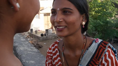 Handheld closeup shot of two beautiful ladies sharing and gossiping on a terrace Stock Footage 92718807