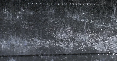 Handheld detail view of rain falling on dark ground at night 4K Stock Footage 109425516