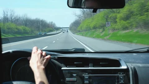 Handheld Driving Perspective on Sunny Multi-lane Highway with Green Foliage Stock Footage 332680263