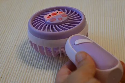 Handheld fan on a bed Stockfoto's