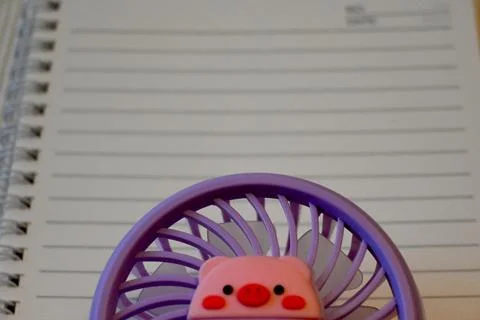 Handheld fan on a notebook Fotos Stock