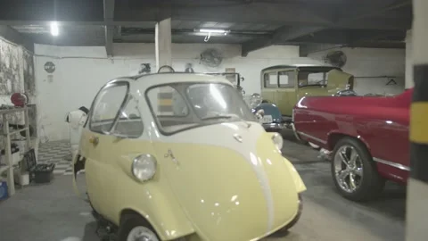 Handheld image of a garage with several old cars. Stock Footage 136137207