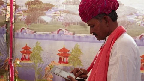 Handheld Indian man busy on a touchscreen tablet Stock Footage 69788313