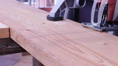 Handheld jig saw cutting a pice of wood Stock Footage 132355697