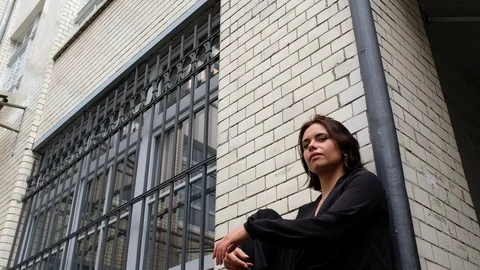 Handheld low angle view of beautiful woman sitting and posing Vídeo Stock 120420726