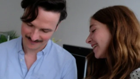 Handheld low angle view of mid adult woman and man discussing party details Video stock 120422628