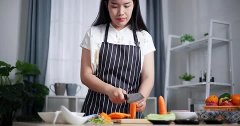 Handheld low angle view shot, Beautiful Asian woman cutting carrots with kn.. Stock-Footage 308431770