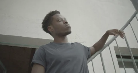 Handheld low angle view of thoughtful young man standing against railing Stock Footage 120427122