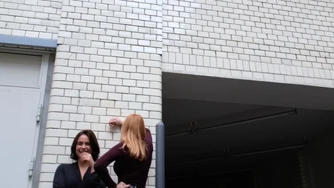 Handheld low angle view of two beautiful women posing and talking Vídeo Stock 120422519