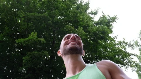 Handheld low angle view of young man sitting and talking to camera Stock Footage 120418913