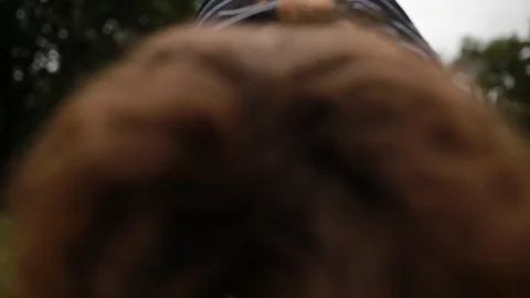 Handheld low angle view of young woman with curly hair practicing yoga 스톡 동영상 120425917